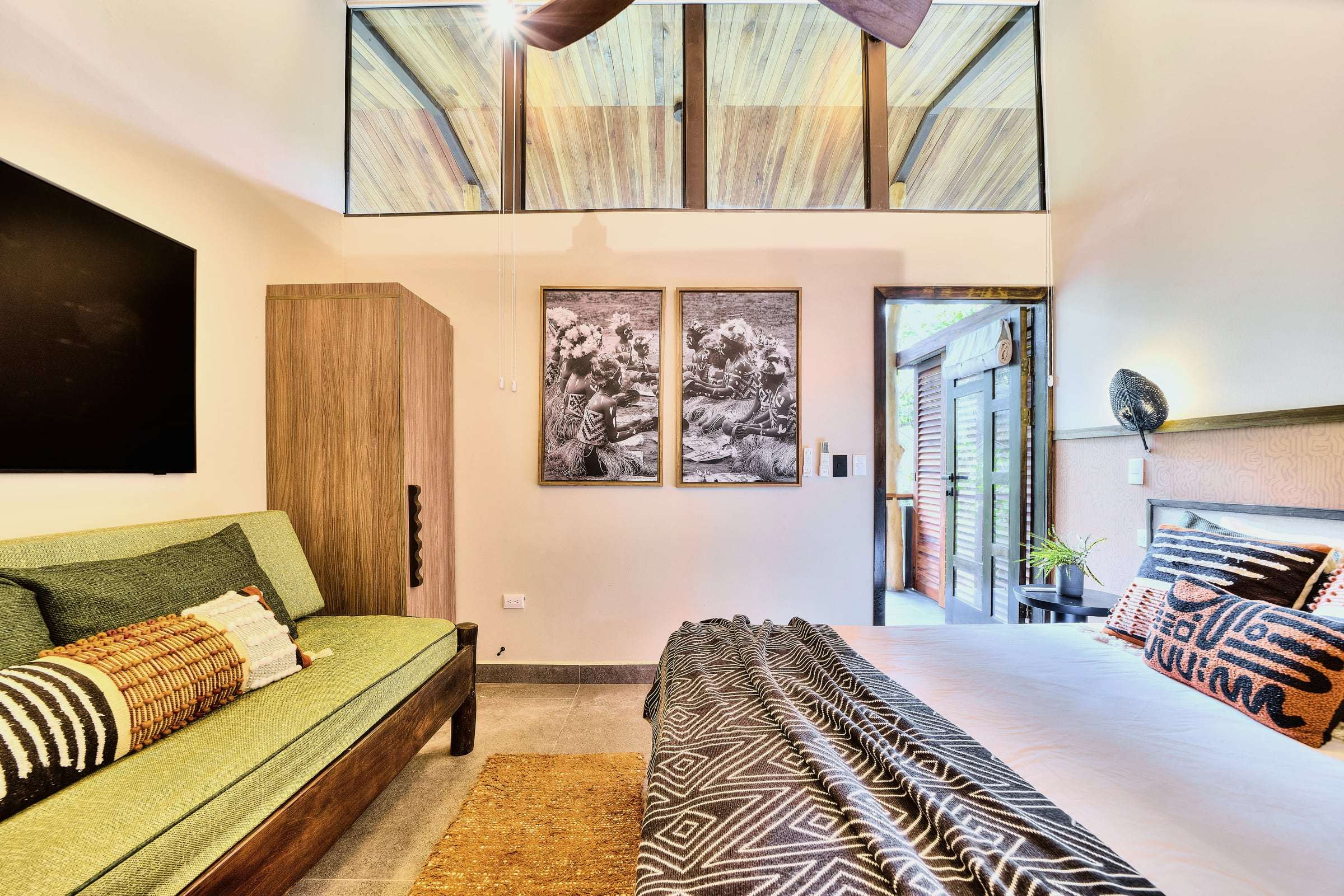 Terrace Suite: king bed, green daybed, black-and-white prints and clerestory windows, with the terrace door open