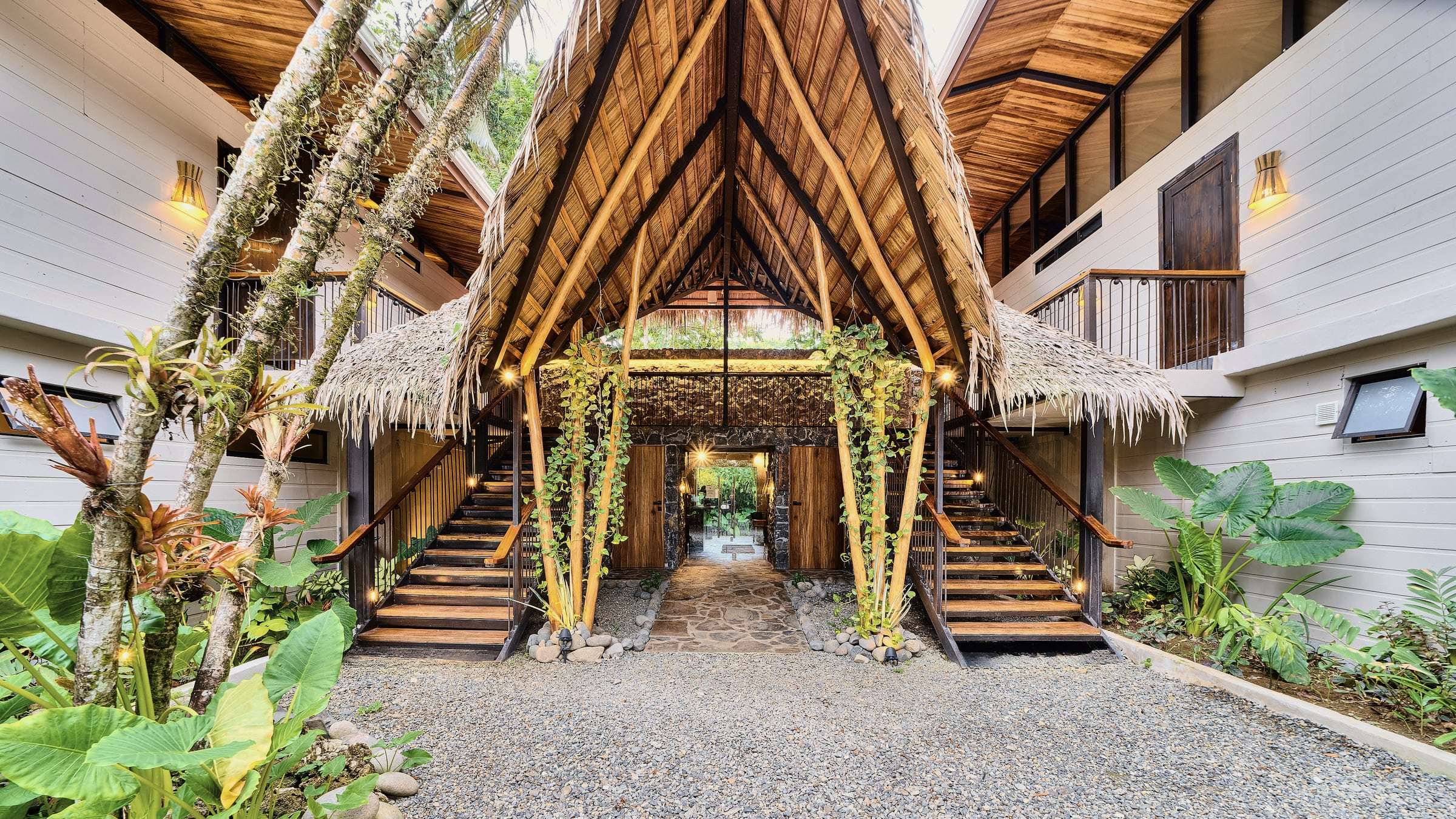 Conga Boutique Hotel's thatched A-frame entrance by day, with twin wooden stairs rising to each wing